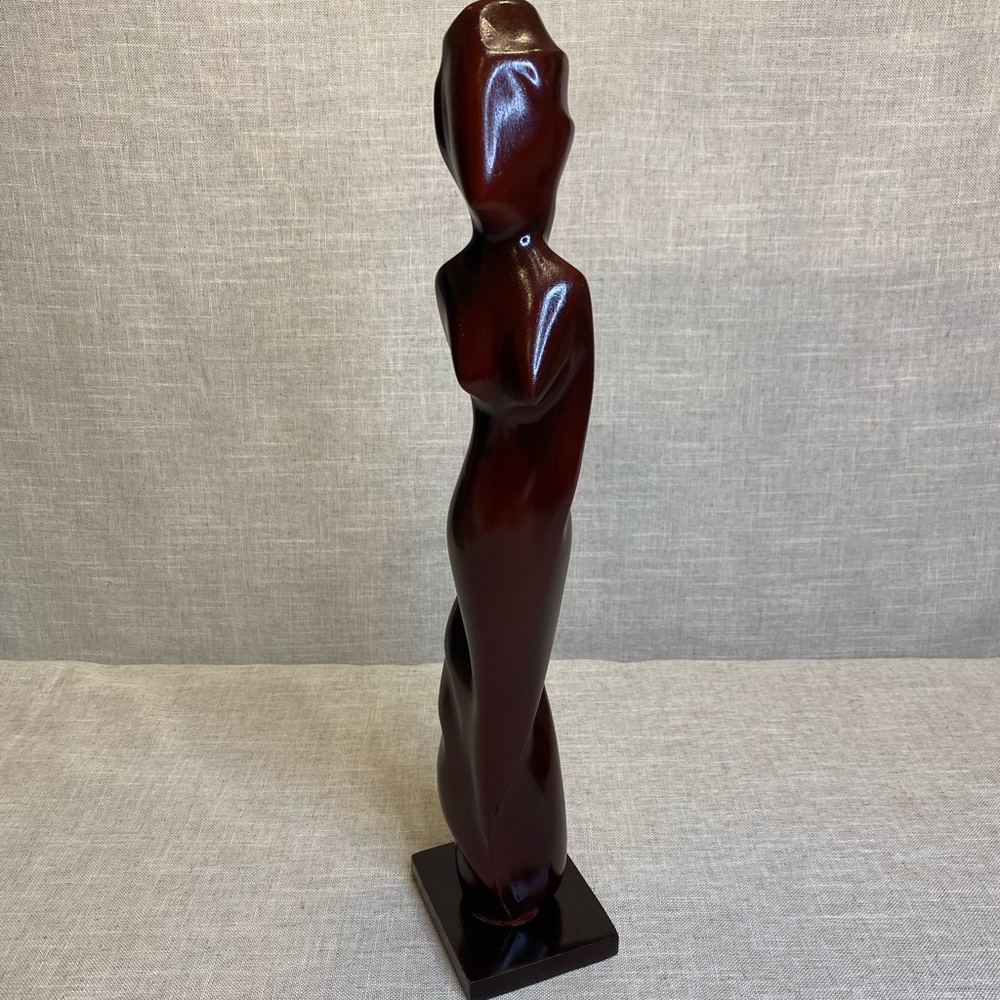 Tall wood sculpture of silhouette of woman.